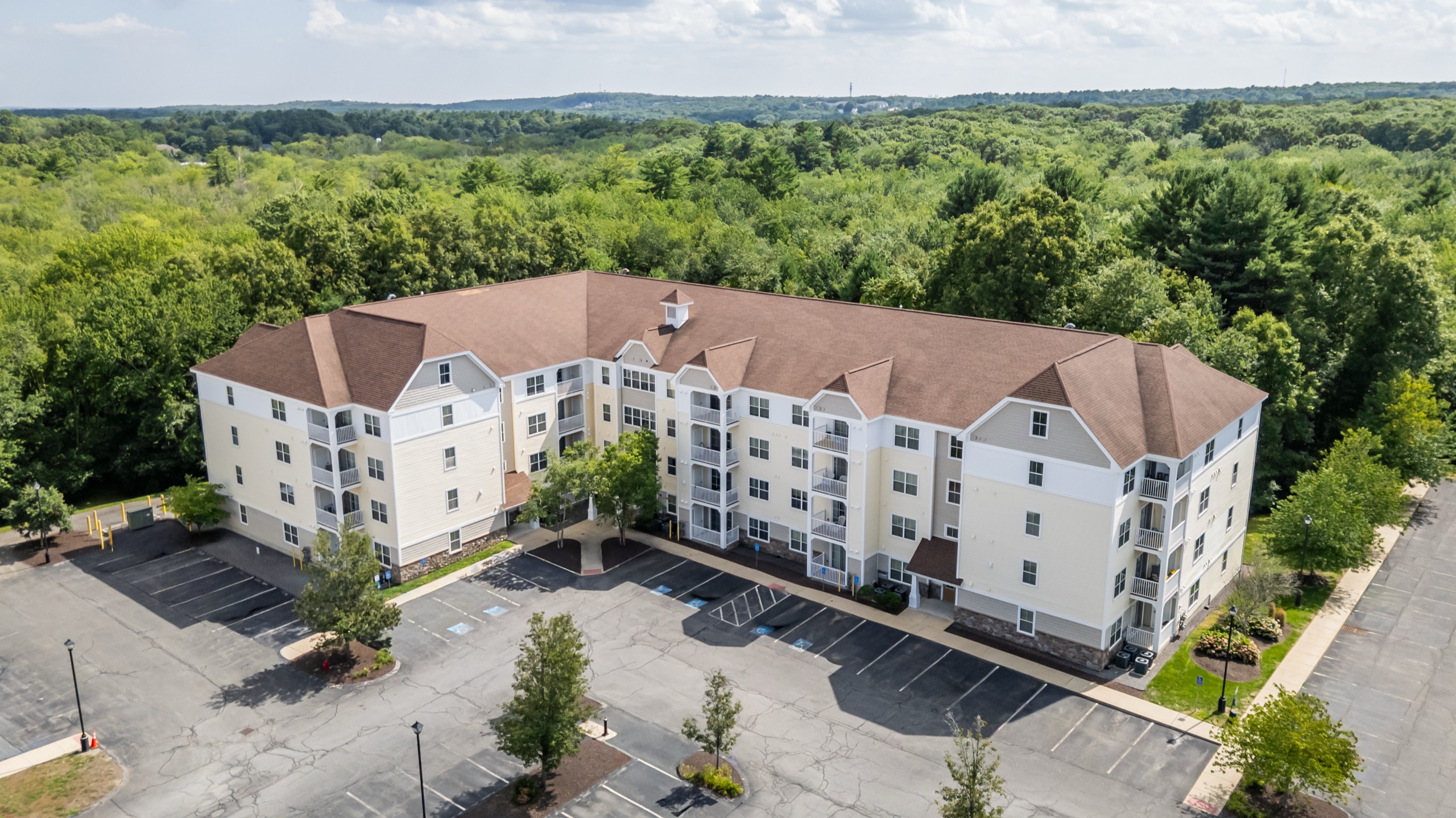 Aerial view of Edgewood Apartments in Plainville, Massachusetts, framed by woodland.